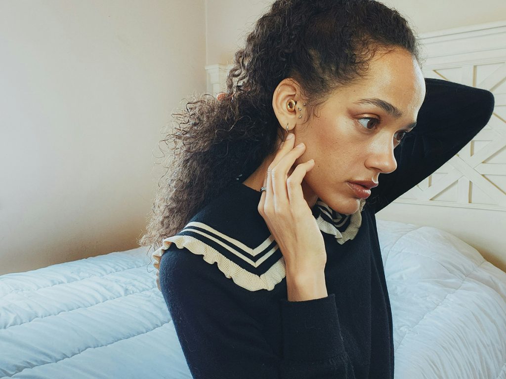 young woman sitting on a bed